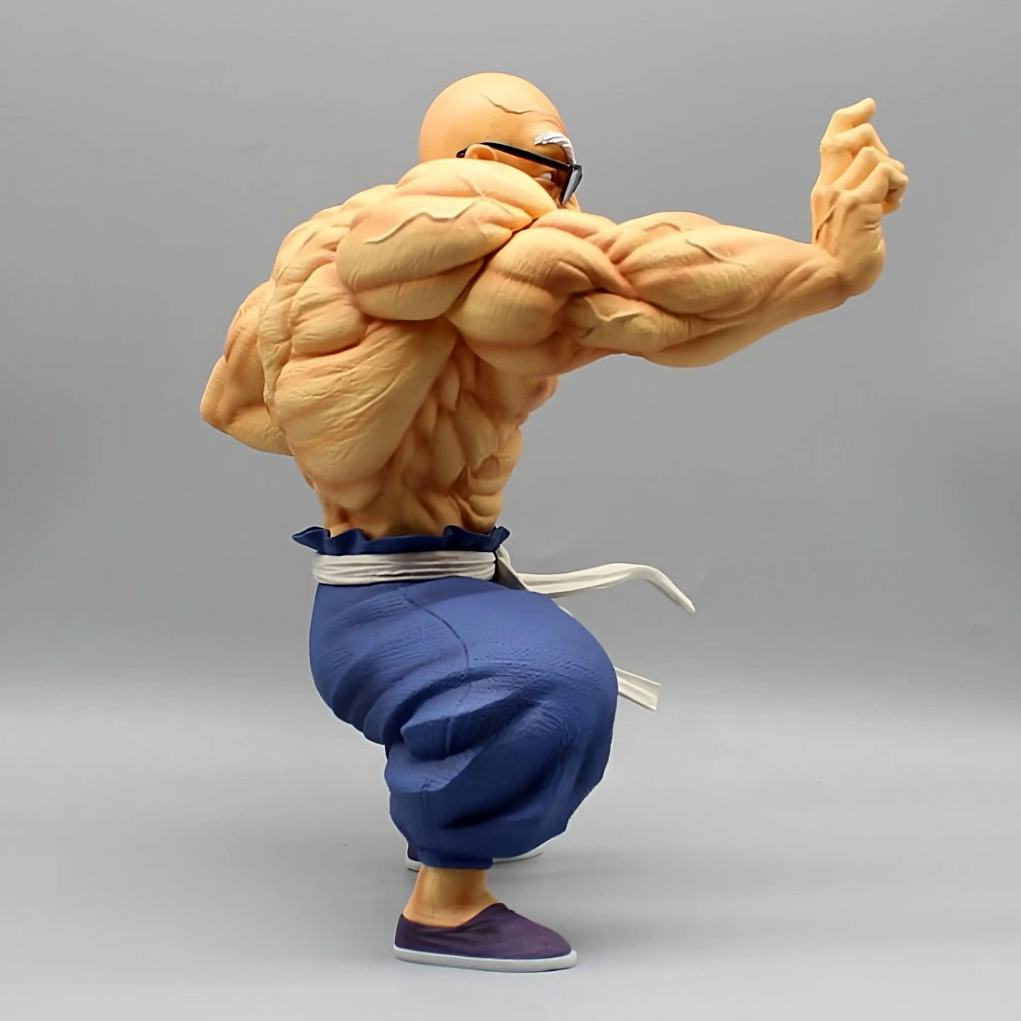 Muscle Master Roshi figure from Dragon Ball, angled to the side, showcasing his bulging muscles and combat-ready stance.