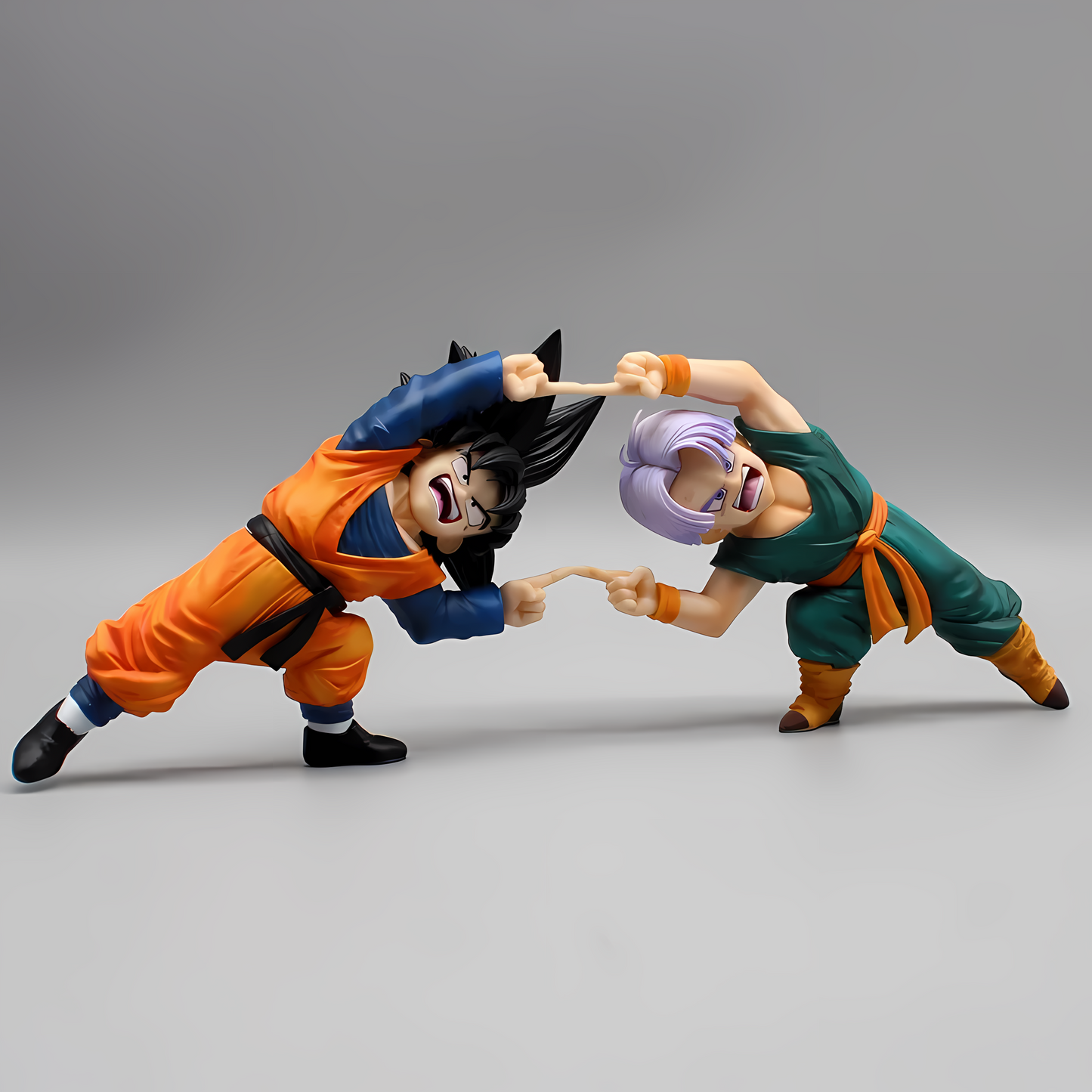 Dragon Ball figures of Goten and Trunks in mid-fusion, captured from the front on a plain grey background, highlighting the precision of their synchronization.