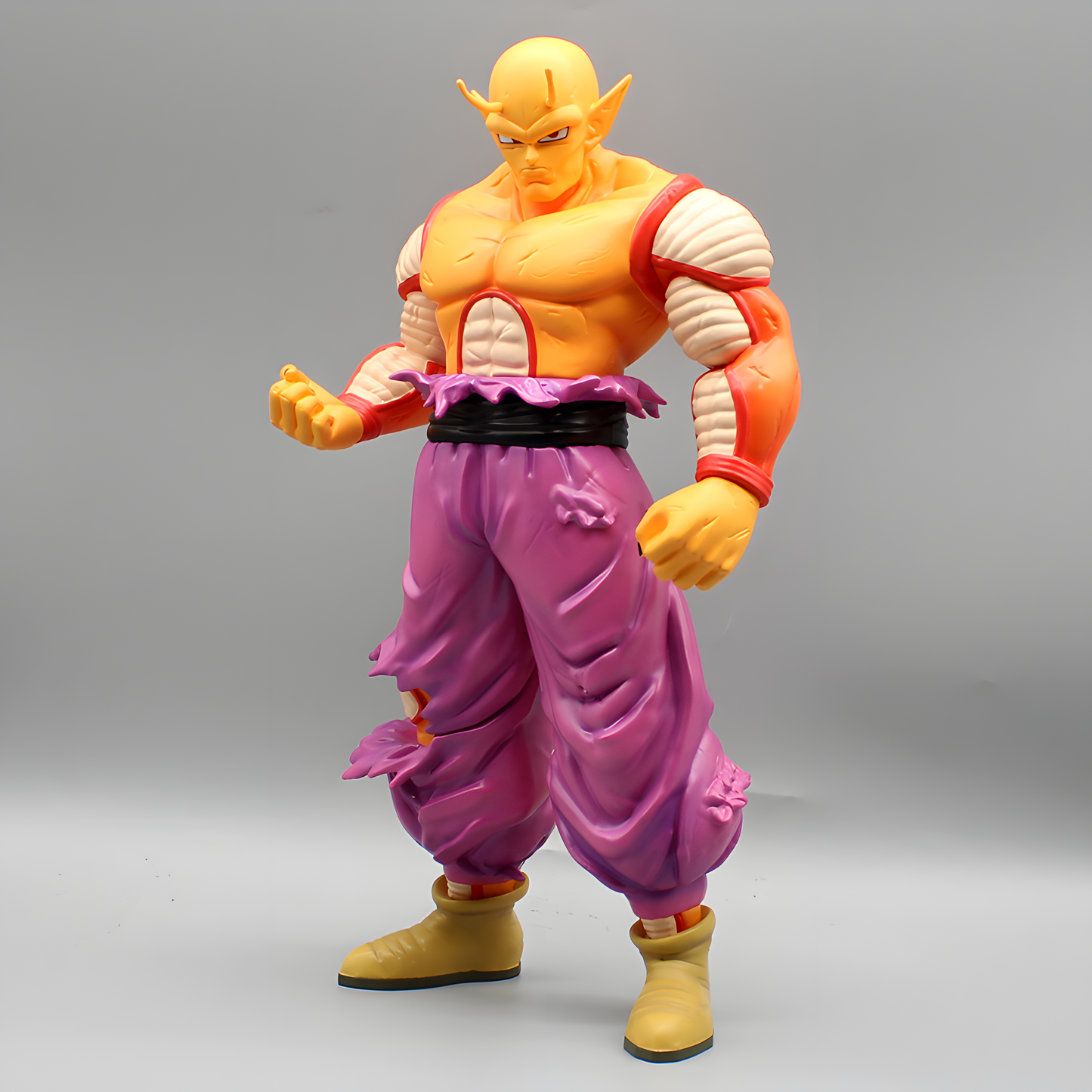 Detailed Dragon Ball figure of Piccolo in combat-ready stance, featuring his signature purple pants and pointed ears, against a neutral background.