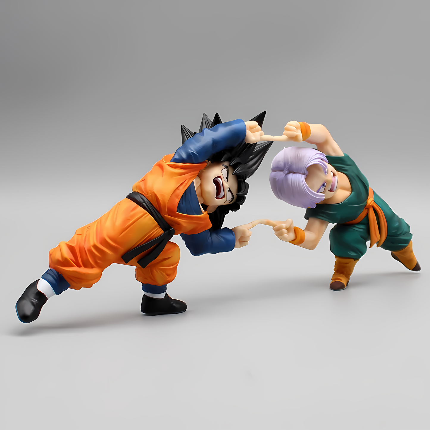 Side view of Goten and Trunks collectible figures performing the fusion dance, showcasing their focused expressions and the fluidity of their movements.