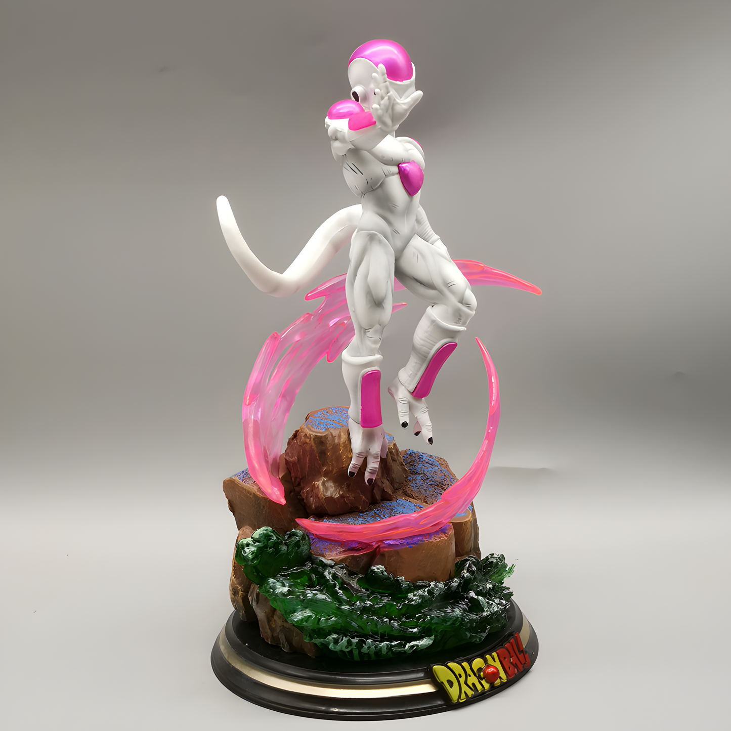 Iconic Frieza figure from Dragon Ball, poised elegantly atop a rocky base enveloped by his trademark pink energy whirl, set against a studio background.