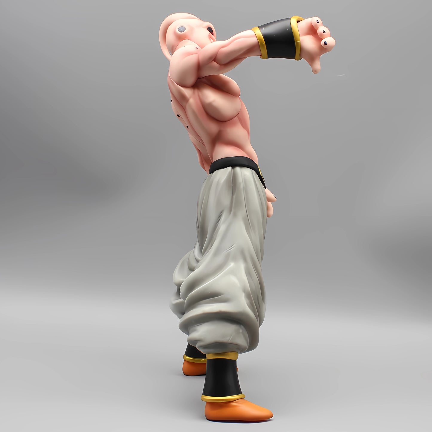 Detailed side view of the 'Malevolent Majin Buu' figure from Dragon Ball, showcasing the character's muscular physique and the flowing grey pants, on a plain background.