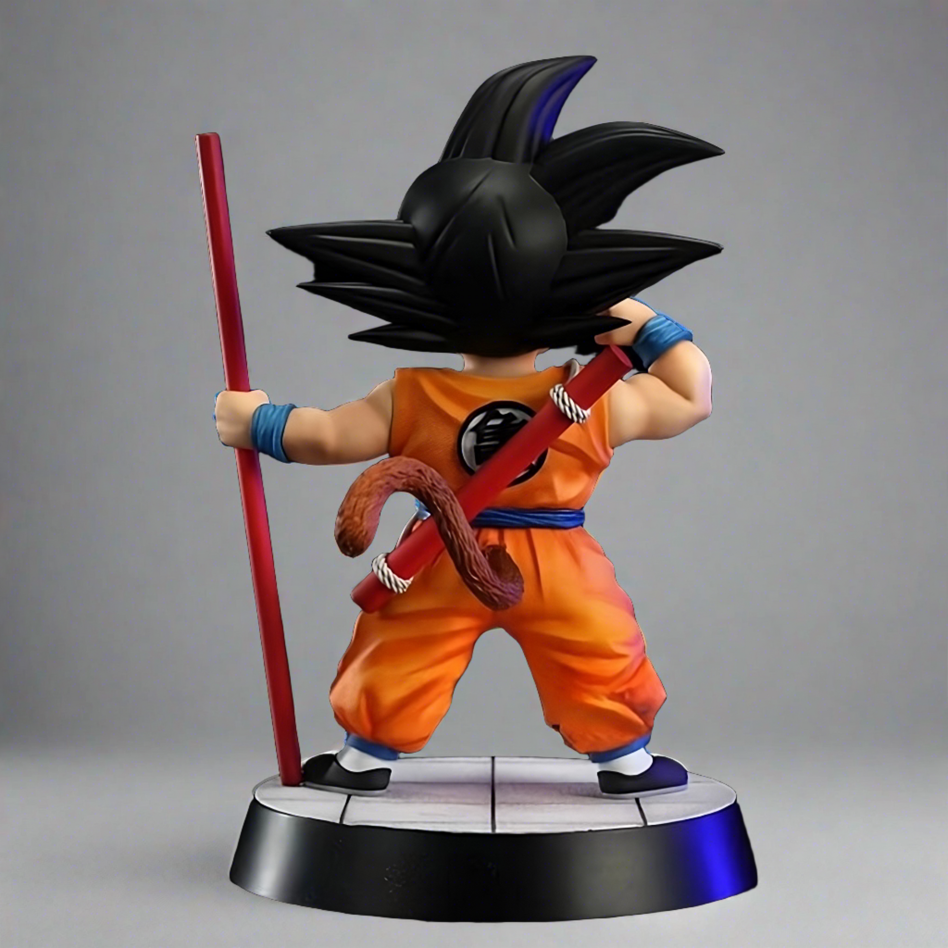 Rear angle of the young Goku collectible figure from Dragon Ball, showcasing his iconic tail and Power Pole, poised for action on a display base.