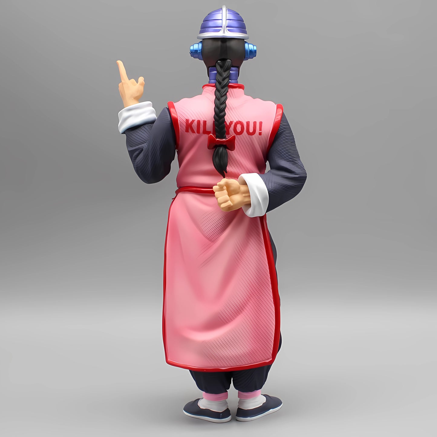 Rear view of the Tao Pai Pai figure with text 'KILL YOU!' on the back of his outfit, gesturing menacingly over his shoulder, presented against a neutral gray background.