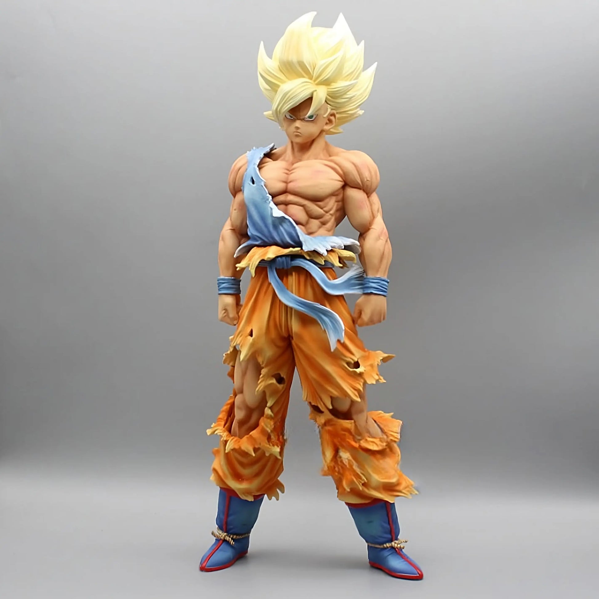 The collectible figure 'Ascend to Saiyan Glory Goku' from Dragon Ball showcases Goku with his signature golden Super Saiyan hair and a muscular build. He's dressed in a battle-worn orange gi torn to reveal his physique, standing confidently in blue boots, with the focus on his intense expression and the power of his Saiyan form, all against a neutral background.