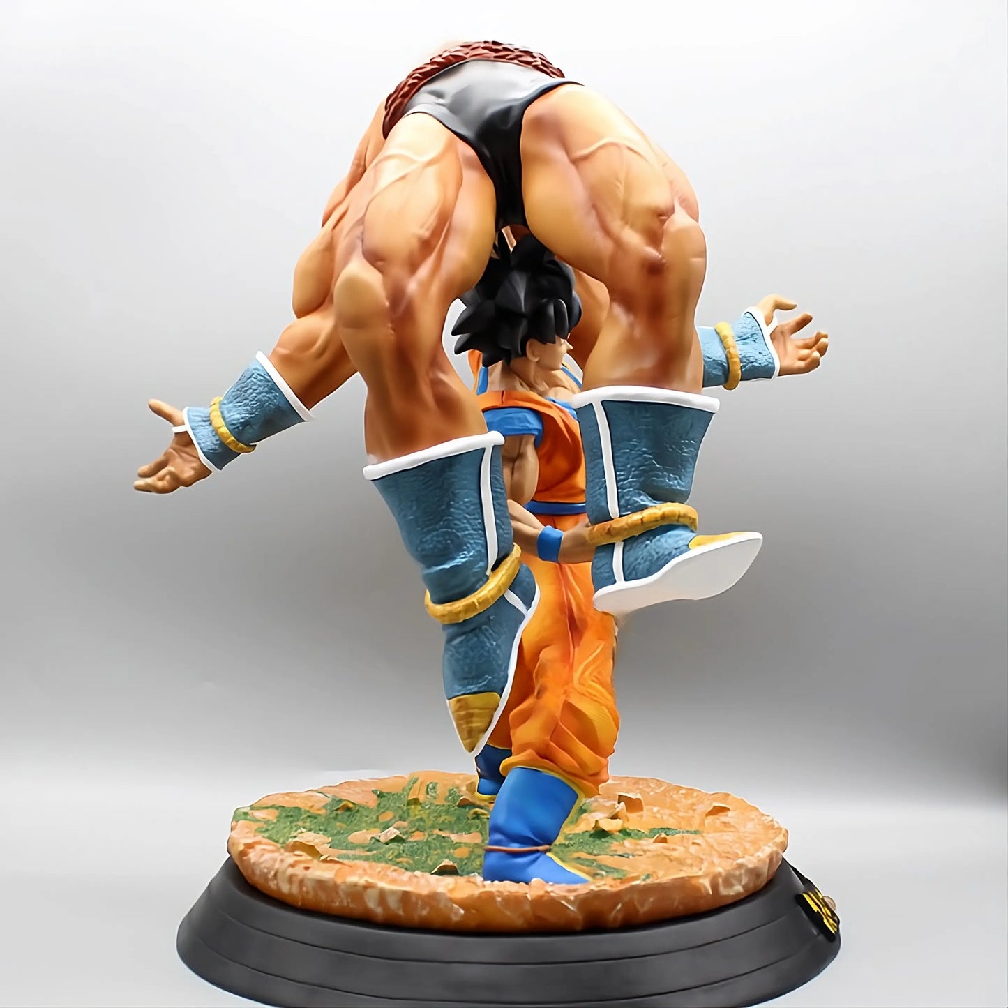 Dramatic angle of Goku standing defiant in front of the mighty Nappa, showcasing his strength and determination in the Dragon Ball collectible figure series.