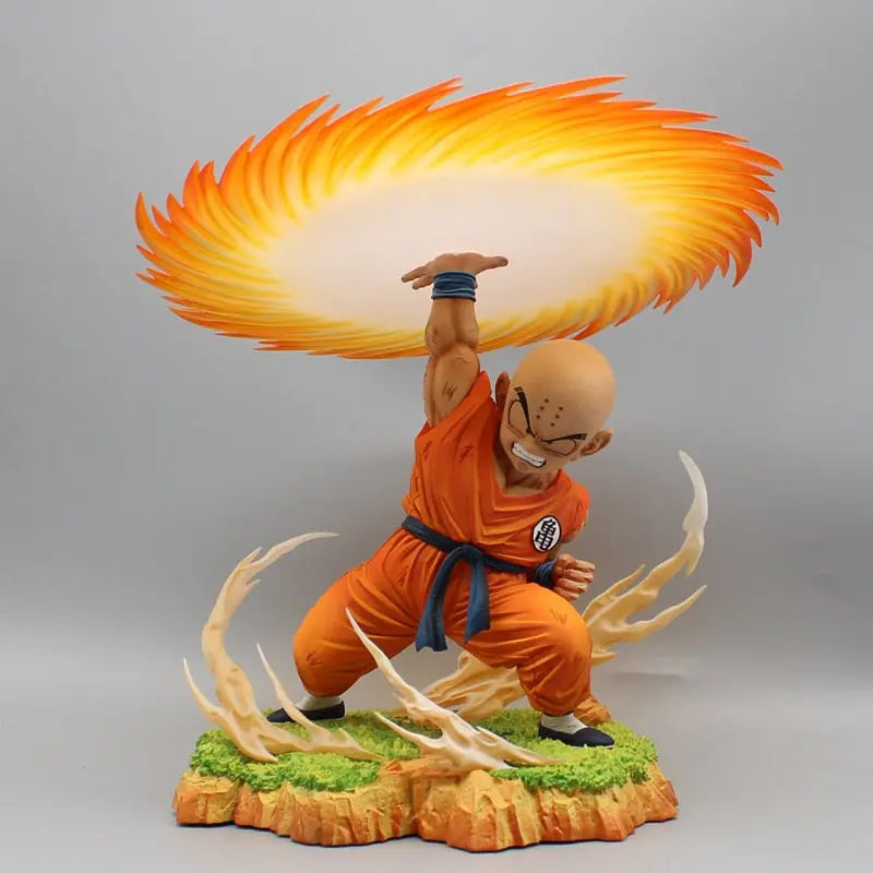 Striking Dragon Ball Z figurine of Krillin executing the iconic Kienzan technique, with a radiant orange and yellow energy disc above, grounded on an earthy base with dynamic white energy effects, capturing a key battle moment for Krillin fans.