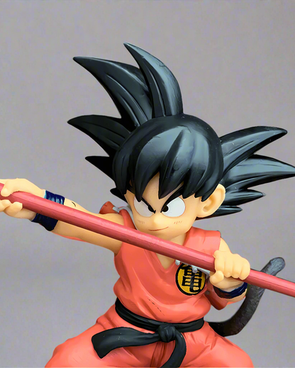 Intense Dragon Ball figure of 'The Adventures Begin' Goku, gripping his Power Pole ready for action, set before an explosive orange backdrop, a must-have for collectors.